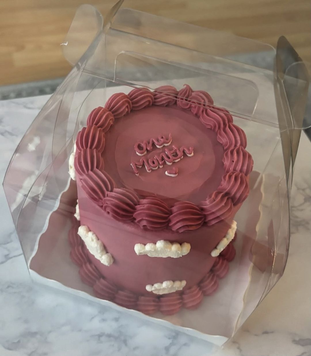 Raspberry-pink bento cake with piped clouds and “One month” on top (photo 2 of 3)