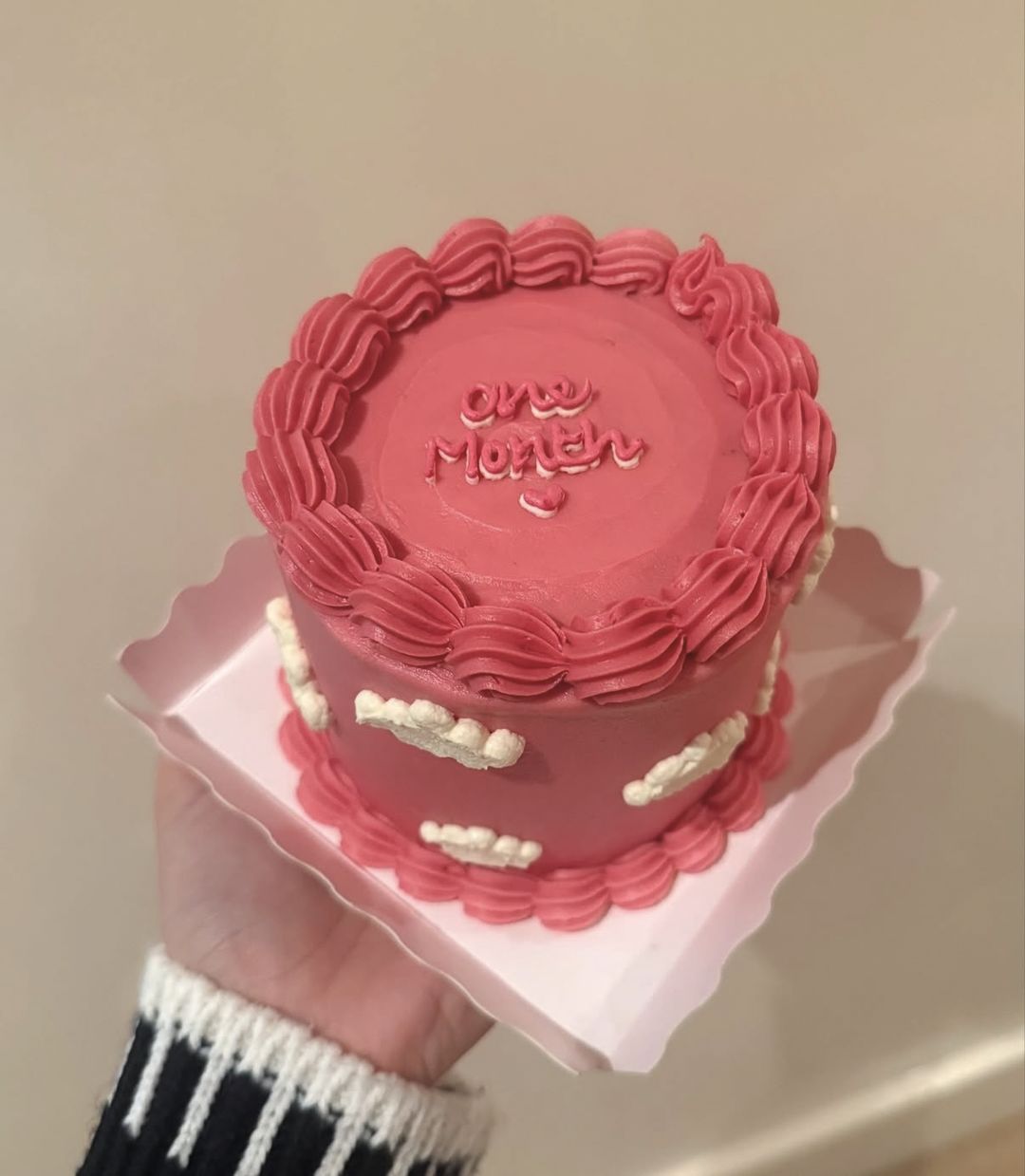 Raspberry-pink bento cake with piped clouds and “One month” on top (photo 3 of 3)