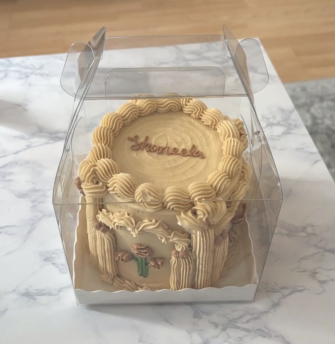 Caramel-coloured bento cake piped with gothic arches and columns, in a clear gift box