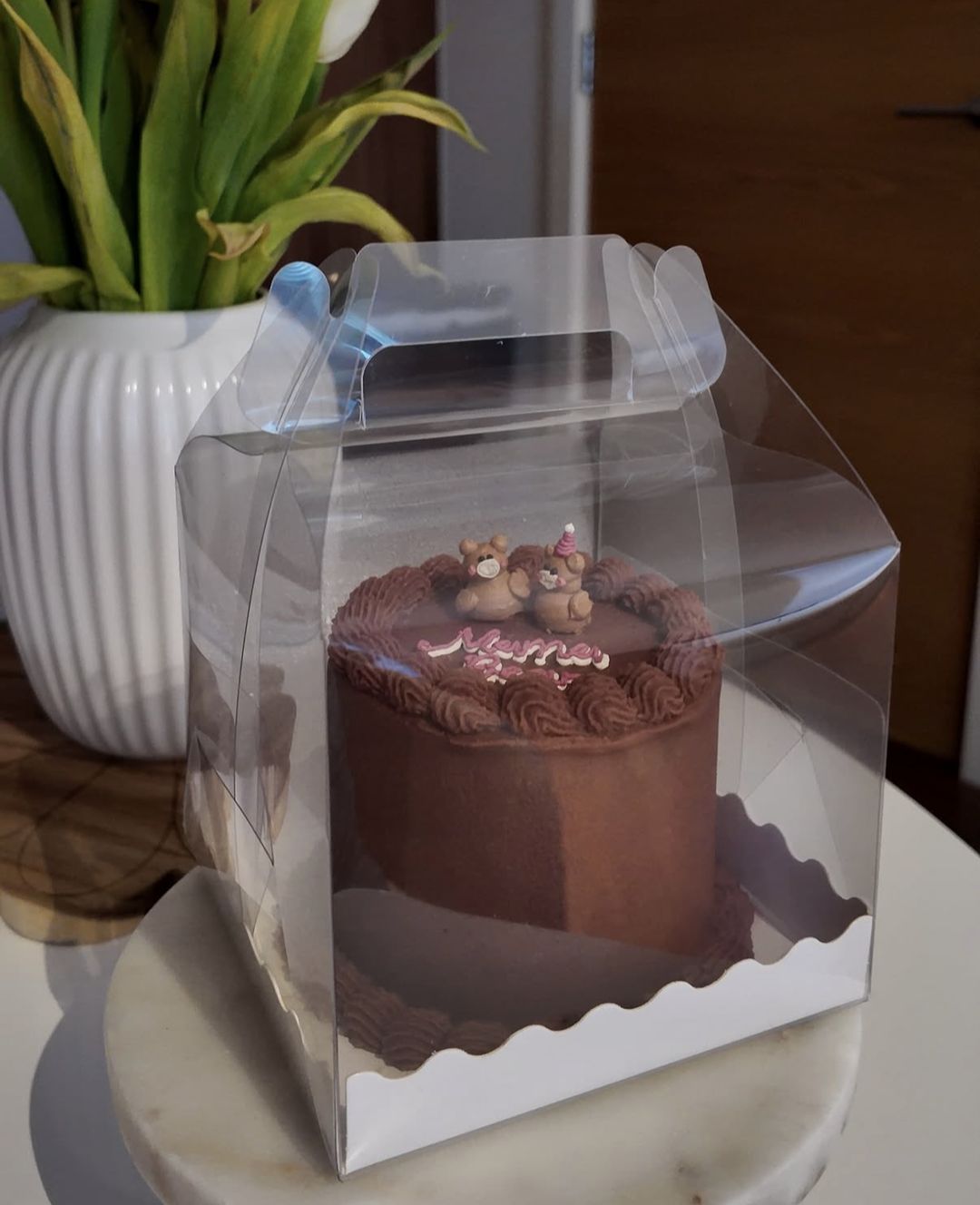 Chocolate bento cake topped with little bears and “Mama” in pink, in a clear gift box (photo 2 of 2)
