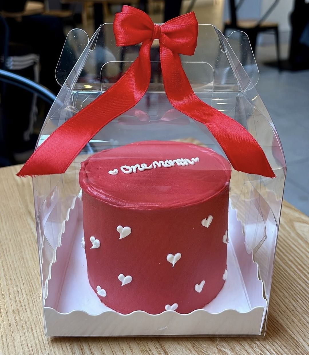 Red bento cake with white piped hearts and “One month” on top, tied with a red satin bow (photo 2 of 2)
