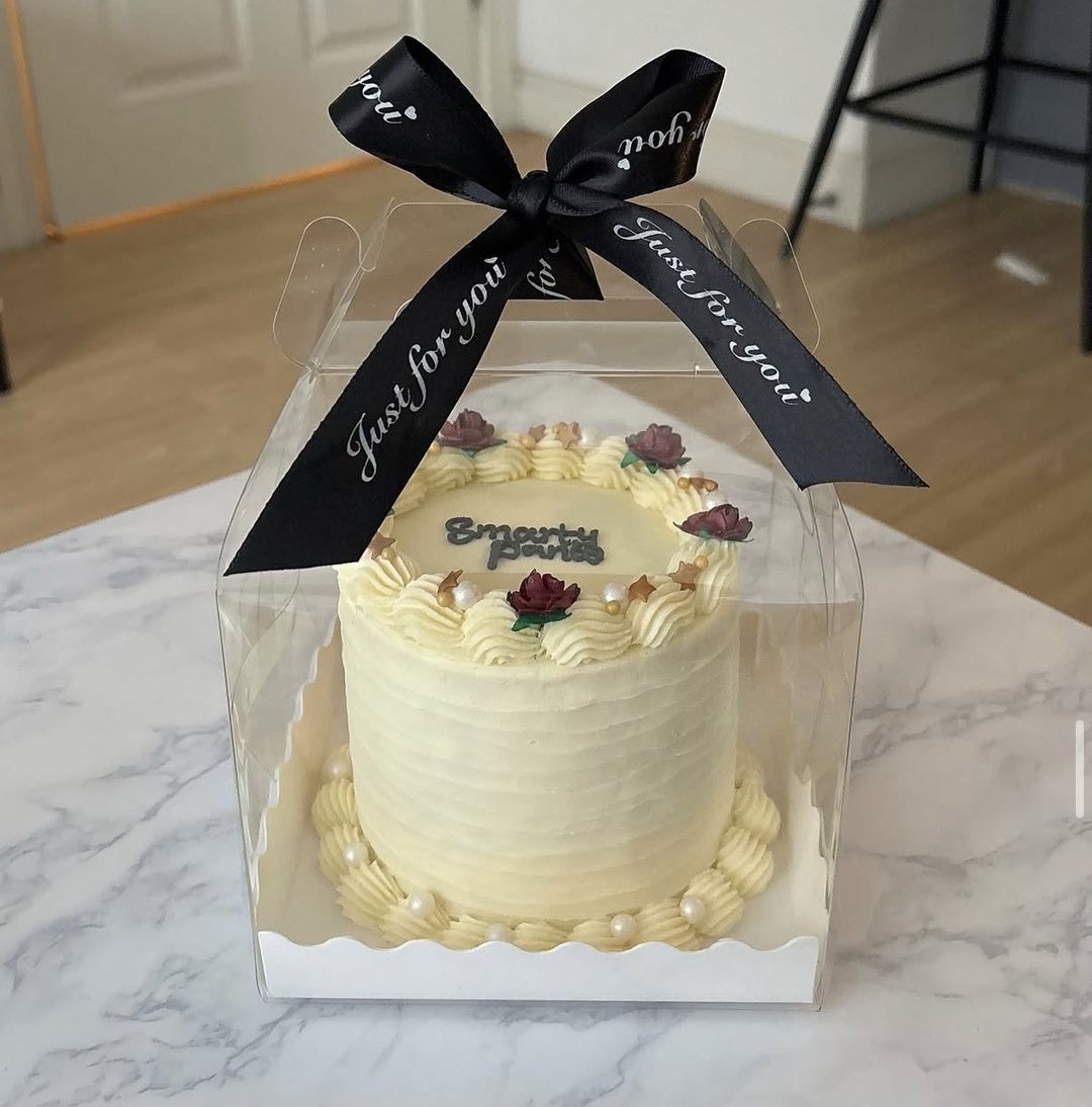 Cream bento cake with “Smarty pants” on top, red roses, gold stars and pearls, tied with a black ribbon (photo 1 of 2)